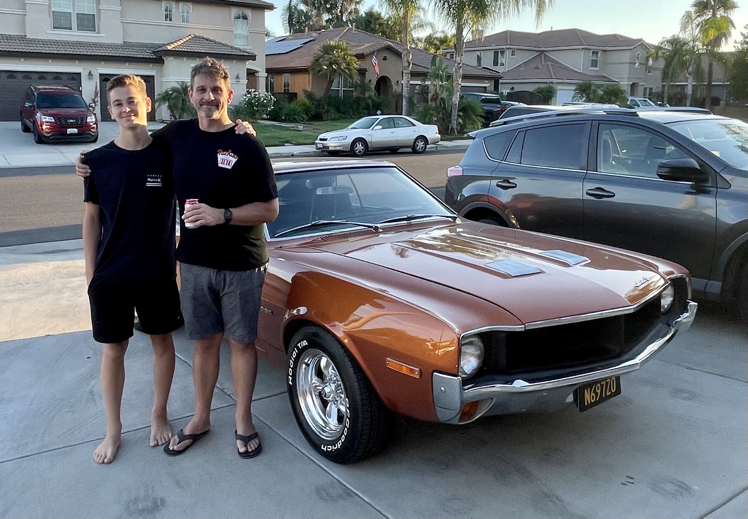 Jason and Hemi standing together in front of Hemi’s copper-colored 1970 AMC Javelin, which they built together.